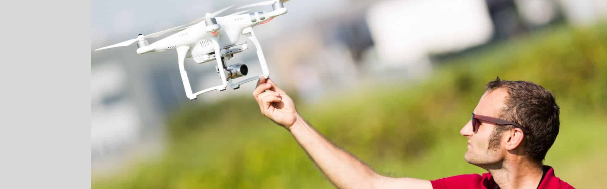 Pilot with his flying drone TitelbildDrone FPVSlider Drohne